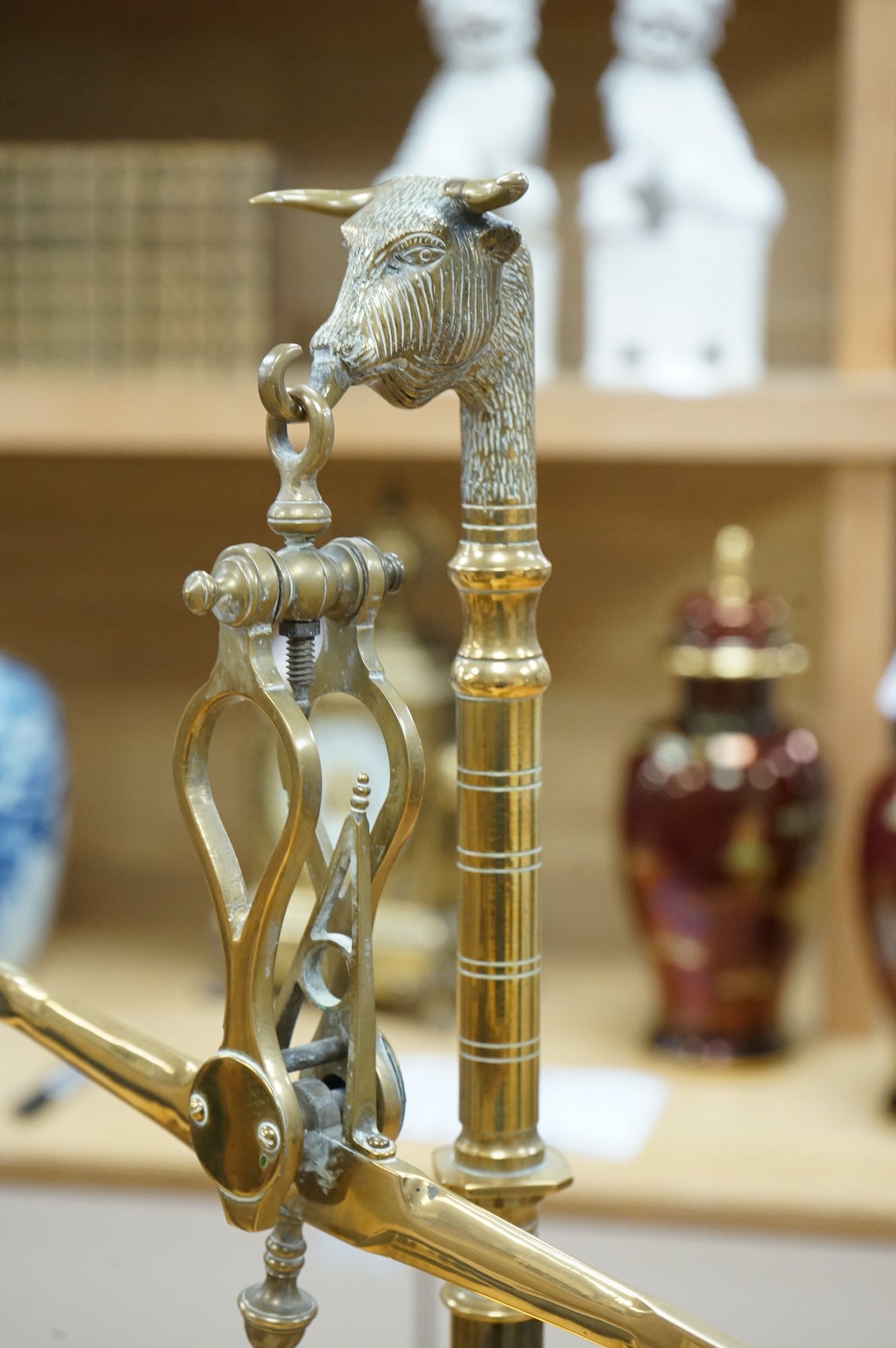 A pair of brass beam scales with decorative bull's head finial and weights, 56cm high